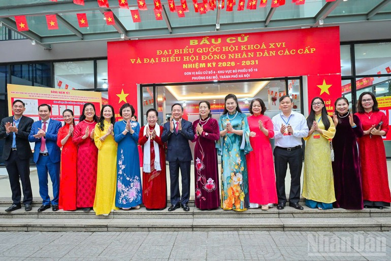 越共中央委员、中央书记处书记、中央宣教与民运部部长郑文决和选民在河内市第16号选区参加选举投票后合影留念。