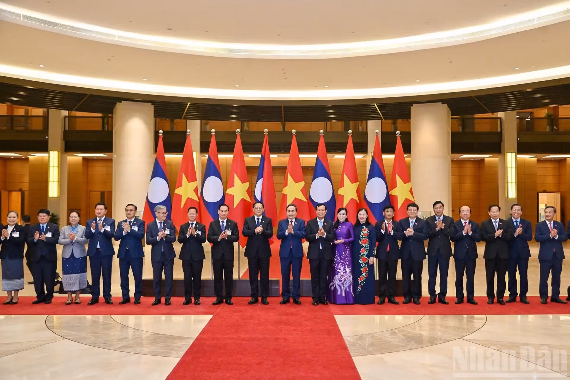 越南国会主席陈青敏和老挝总理宋赛·西潘敦以及双方代表合影。