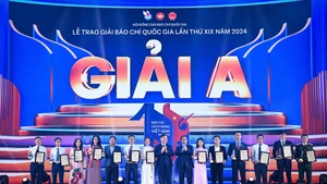 范明正总理，中央宣教与民运部部长阮重义向A等奖得奖者颁发奖状。