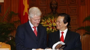 2010年11月14日，时任越南政府总理阮晋勇在河内向美国前总统比尔·克林顿赠送由越南公安部出版社出版的《我的人生：比尔·克林顿》一书。（图片来源：越通社）
