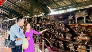 游客参观一幅长近25米、重约20吨的巨型流木画作。该画作被认为越南最为精工细作的作品之一。（图片来源：越通社）