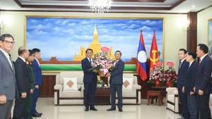 越南驻老挝大使阮明心转交越共中央总书记苏林致老挝人民革命党建党71周年的花篮。（图片来源：越通社）