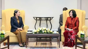 裴氏明怀同志（右）与柬埔寨祖国发展团结阵线国家委员会主席梅森安亲切交谈。