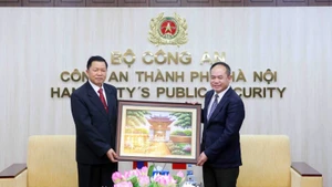 河内市公安局局长阮青松中将（右）会见老挝人民革命党中央书记、公安部长万通·孔玛尼上将。