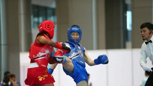 阮氏秋水（蓝衣）击败缅甸对手，夺得女子60公斤级散打金牌，为越南赢得当日首枚金牌。