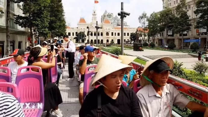 游客乘坐胡志明市双层巴士参观游览。（图片来源：越通社）