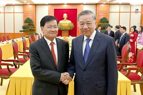 越共中央总书记苏林与老挝人民革命党中央总书记、国家主席通伦·西苏里亲切握手合影。
