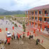 党旗和国旗装饰在教学楼两侧，为奠边省三民小学和初中一贯制寄宿学校校园增添了亮丽色彩。