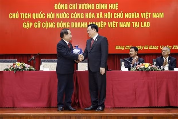 越南国会主席王廷惠会见在老越南企业代表。