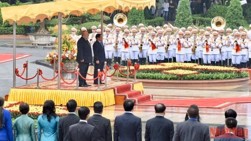 越南政府总理范明正与古巴总理曼努埃尔•马雷罗•克鲁斯向国旗敬礼。（陈海 摄）