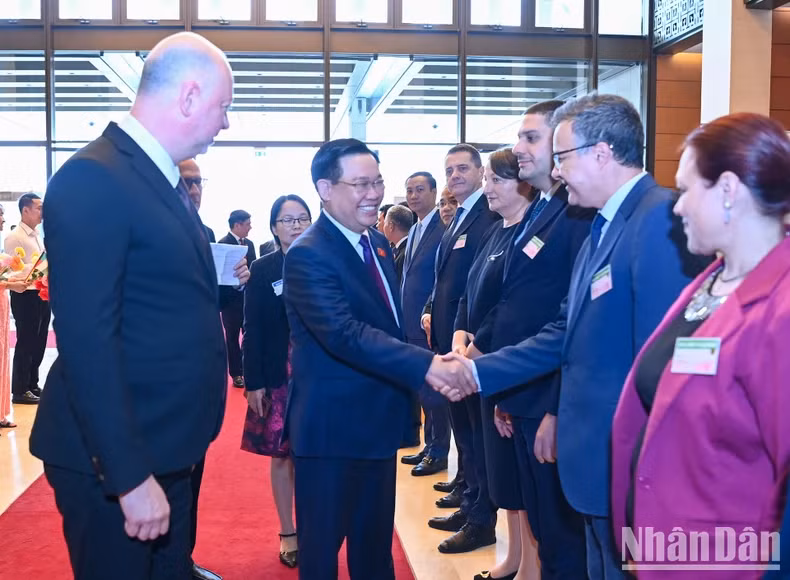 保加利亚议会议长耶利亚兹科夫向越南国会主席王廷惠介绍保加利亚议会高级代表团成员。