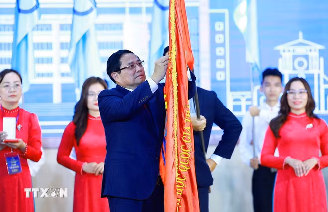 范明正总理代表党和国家领导人向胡志明市国家大学颁发一级劳动勋章。（图片来源：越通社）