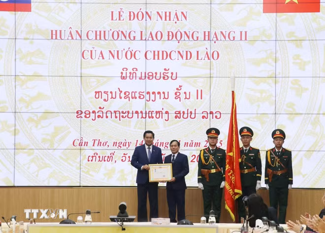 芹苴市市委书记阮文孝向占巴萨克省省委书记、省长阿龙赛·宋那拉特赠送礼物。（图片来源：越通社）