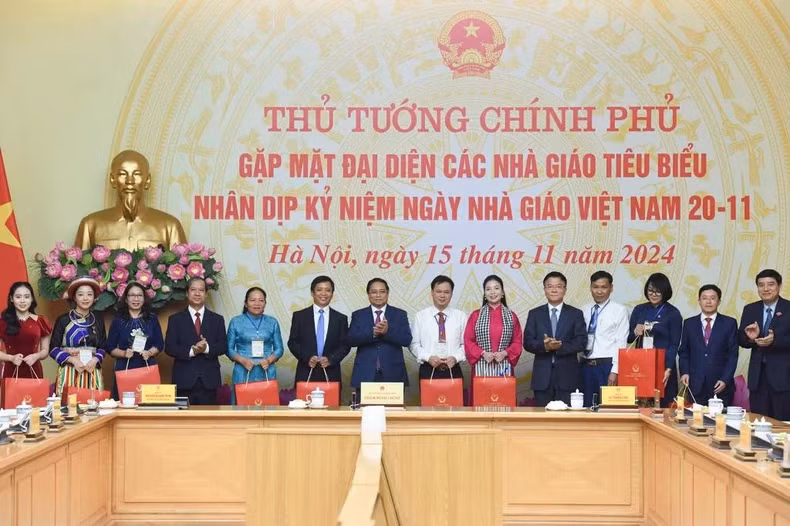 越南政府总理范明正向优秀教师代表赠送礼物。