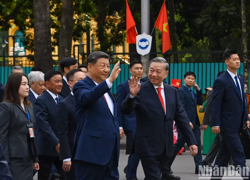 越共中央总书记苏林与中共中央总书记、中国国家主席习近平向首都居民挥手致意。