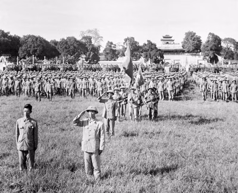1954年10月10日下午15时在旗柱区（现为升龙皇城端门），308号大团司令员、河内军政委员会主席王承羽少将（右）和河内军政委员会副主席陈维兴大夫（左）以及接管河内的308号大团战士们举行首都解放日首个向国旗敬礼仪式。（图片来源：越通社）