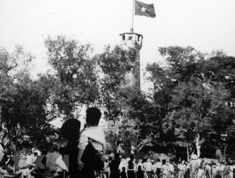 1954年10月10日——首都解放日，民众仰望在河内旗柱上飘扬的国旗。（图片来源：越通社）