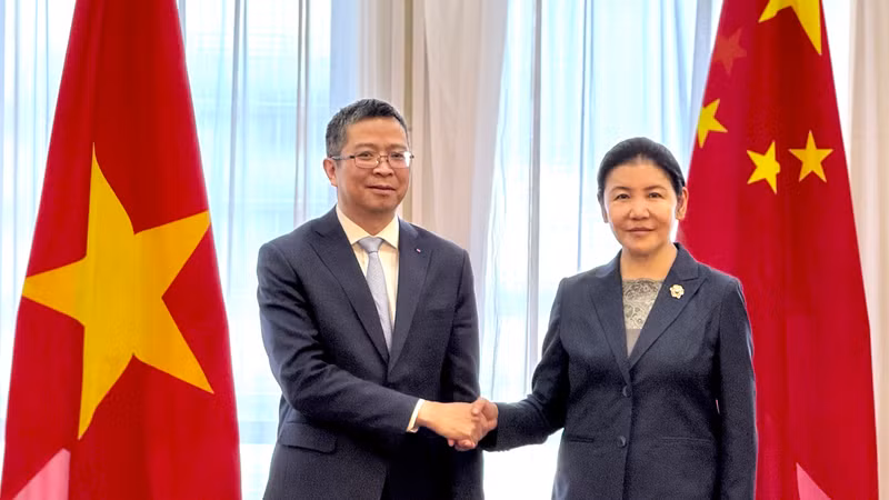 越南驻华大使范清平与中国司法部部长贺荣握手。
