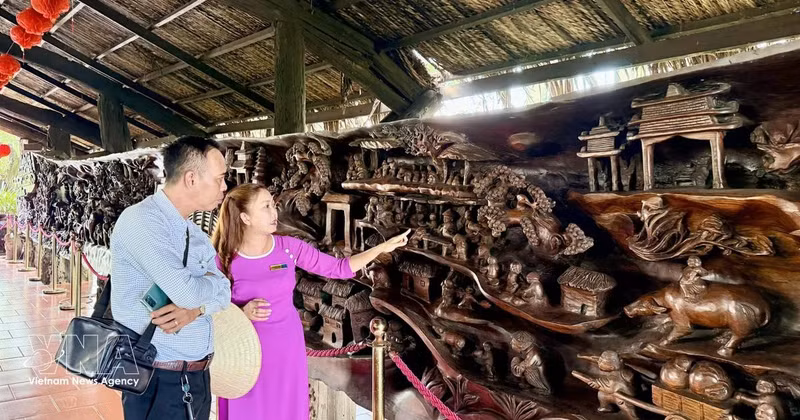 游客参观一幅长近25米、重约20吨的巨型流木画作。该画作被认为越南最为精工细作的作品之一。（图片来源：越通社）