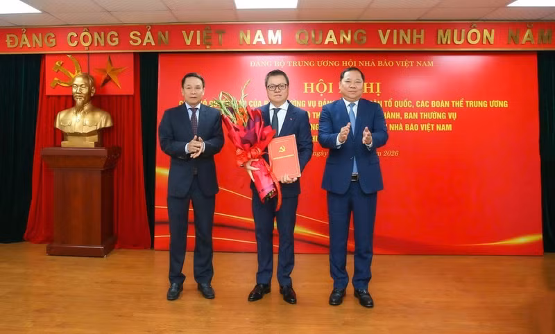 任命黎国明同志（中）为越南新闻工作者协会中央党委书记。