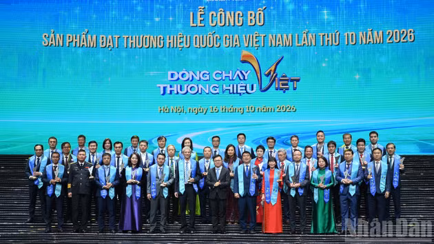 越共中央委员、越南《人民报》社总编辑、中央宣教部副部长、越南新闻工作者协会主席黎国明向在仪式上获得表彰的企业代表赠送纪念品。
