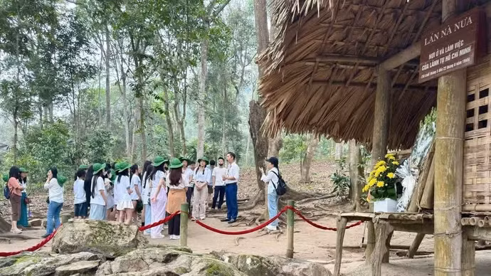 导游向游客介绍宣光省的诺娜棚屋遗迹。