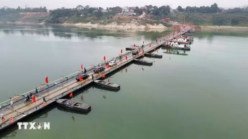 车辆和人民群众在横跨泸江浮桥上出行。