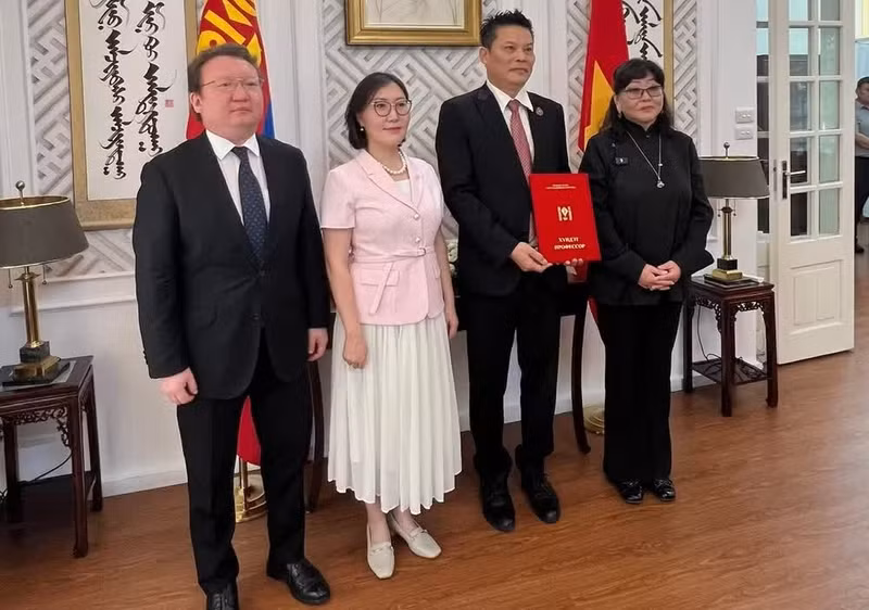 蒙古国驻越南大使冈巴塔尔·胡兰和蒙古国立艺术文化大学代表向导演黎贵阳授予“荣誉教授”称号。（明江 摄）