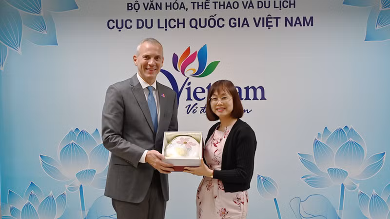 越南国家旅游局副局长阮氏花梅向阿塞拜疆旅游局首席执行官弗罗瑞恩·斯契米德赠送纪念品。（图片来源：TITC）