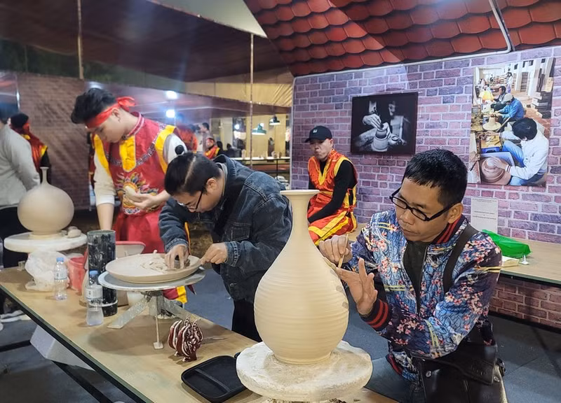钵场陶瓷村陶瓷工艺师在钵场陶瓷村和万福丝织村加入全球创意城市网络“手工艺之都”证书授予仪式暨2025年河内手工艺品展示、演示与创作活动上介绍其村产品。（图片来源：越通社）