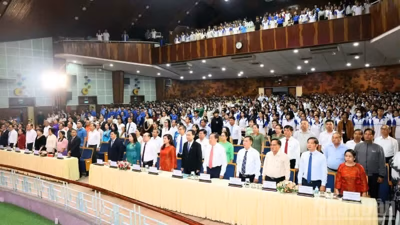 与会代表和嘉宾在越南—菲律宾建交50周年见面会上向国旗行注目礼。