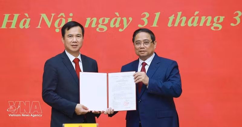 范明正总理向河内国家大学新任校长裴世维颁发任命决定。（图片来源：越通社）