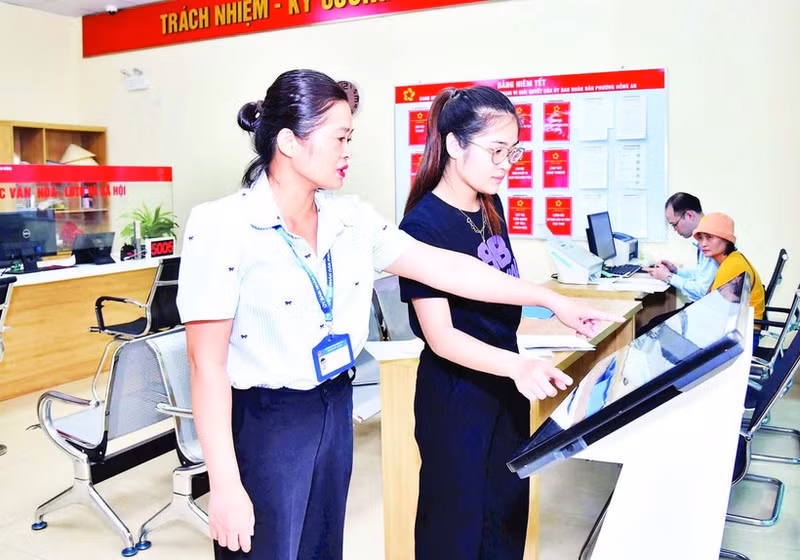 海防市红安坊公共行政服务中心干部职工正在引导群众通过线上方式办理行政手续。