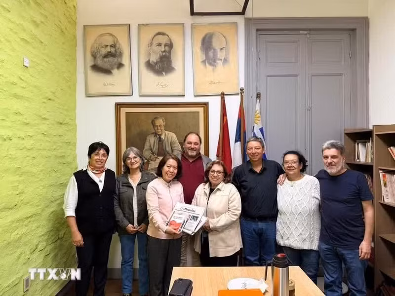 越南驻阿根廷兼驻乌拉圭大使吴明月与乌拉圭共产党代表合影留念。（图片来源：越通社）