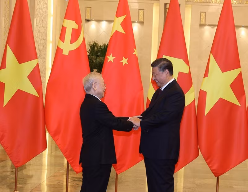 越共中央总书记阮富仲与中共中央总书记、中国国家主席习近平亲切握手。（图片来源：越通社）
