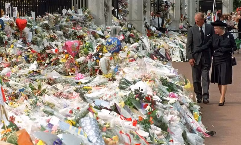 1997年，女王和她的丈夫拿着鲜花放在白金汉宫外悼念戴安娜王妃。（图片来源：PA）