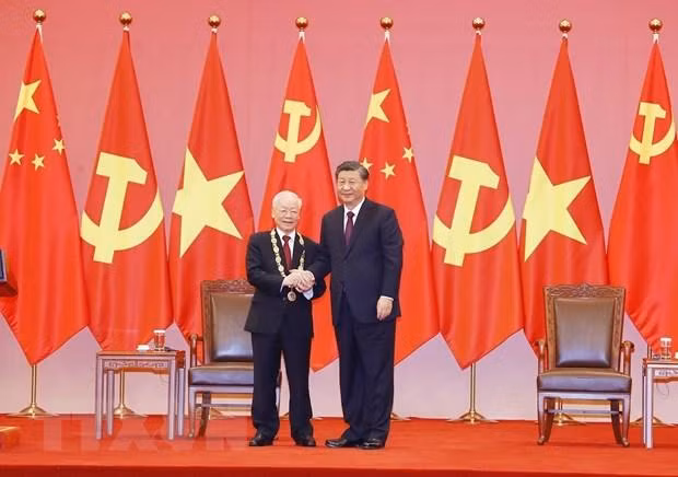 中共中央总书记、中国国家主席习近平在北京人民大会堂向越共中央总书记阮富仲授予中华人民共和国“友谊勋章”。（图片来源：越通社）