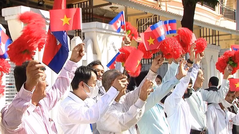 首都金边民众挥舞旗帜和鲜花，欢迎范明正总理和越南代表团。（图片来源：VGP）