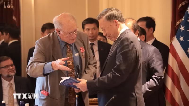 和解与发展基金会主席约翰·麦考利夫向越共中央总书记、国家主席苏林赠送有关越南的书籍。（图片来源：越通社）