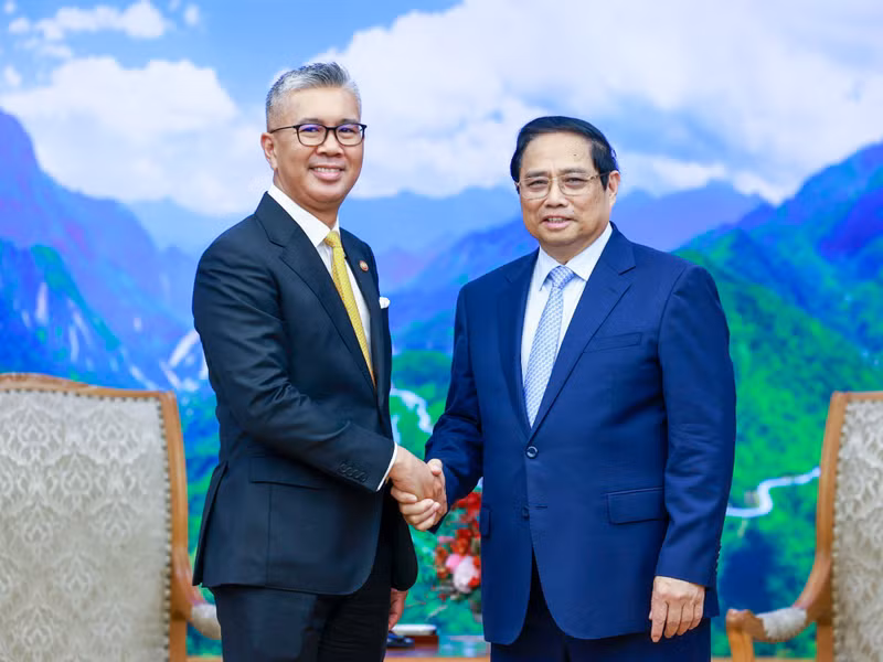 政府总理范明正会见马来西亚投资、贸易和工业部长扎夫鲁·阿卜杜勒·阿齐兹。（图片来源：VGP）