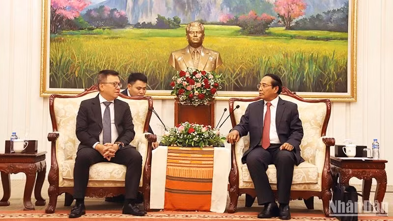 老挝人民革命党中央书记处常务书记、老挝国家副主席本通• 吉马尼会见越南《人民报》社总编辑黎国明。