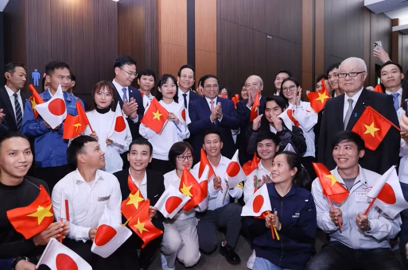 范明正总理同在日越南劳动者合影。