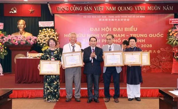 越中友好协会主席阮荣光（左二）向胡志明市越中友好协会在民间外交工作中做出积极贡献的部分集体和个人颁发奖状。