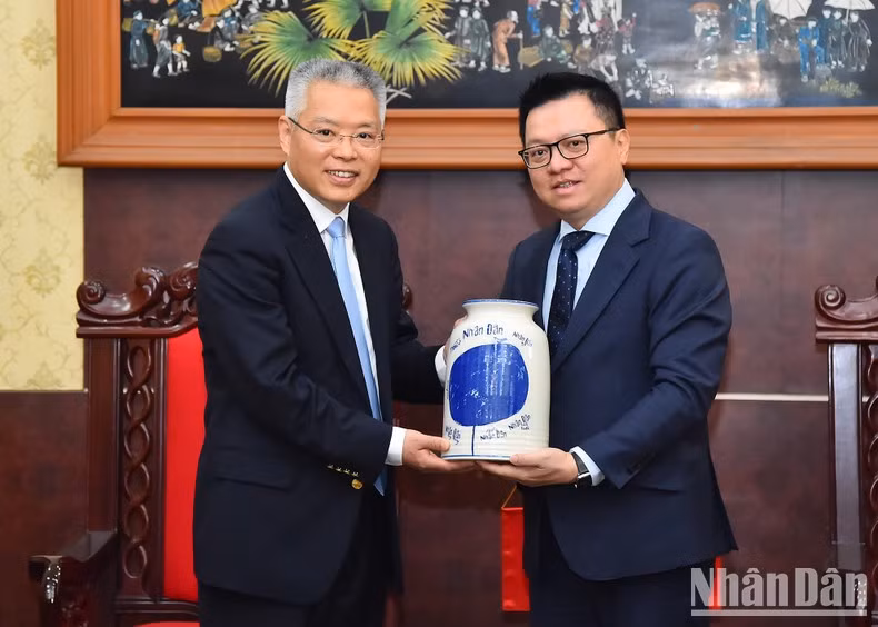 黎国明同志向胡兆明同志赠送礼物。