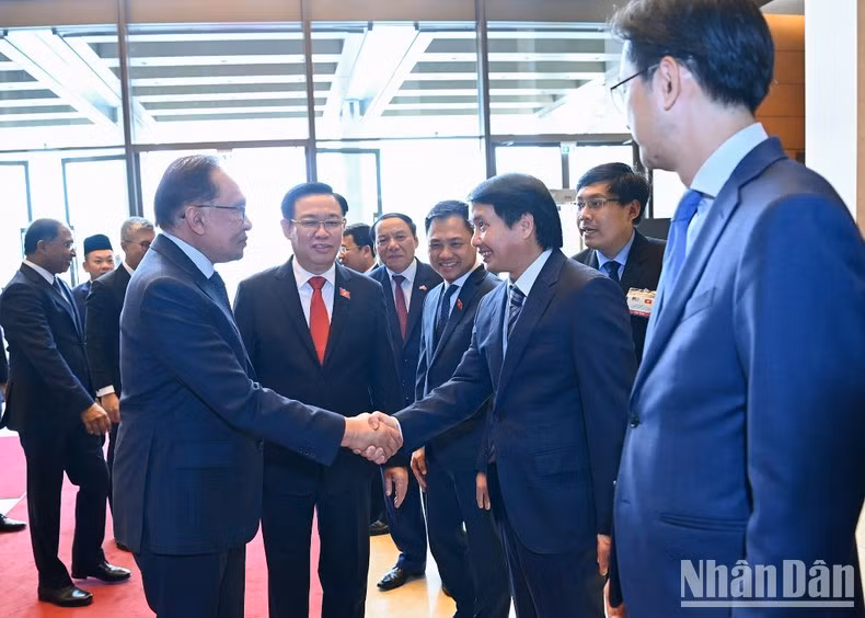 国会主席王廷惠向马来西亚总理安瓦尔·易卜拉欣介绍出席会见的越方代表团团员。