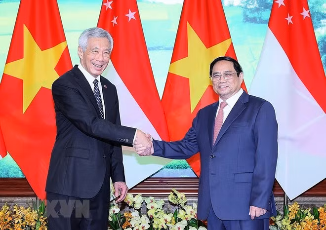 新加坡总理李显龙在2023年8月访问越南期间与越南总理范明正亲切握手。（图片来源：越通社）