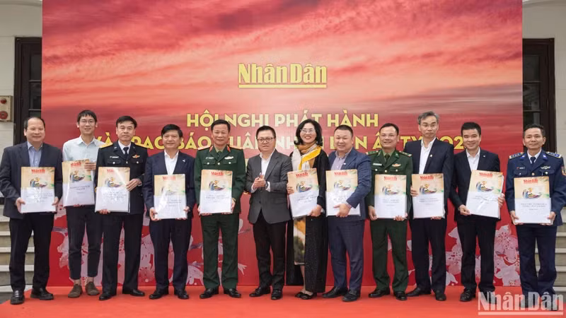 《人民报》社总编辑黎国明和部分单位代表向各单位代表赠送春节特刊。