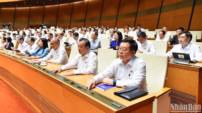 越南国会代表按下表决器表决通过关于2013年《宪法》若干条款修改补充的决议。