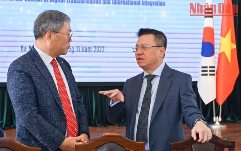 黎国明同志与韩国国际协力机构驻越南办事处首席代表赵汉德在研讨会上交谈。