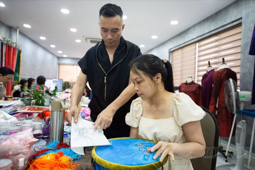 设计师杜郑淮南同员工就布料上的图案刺绣流程进行交谈。 设计师杜郑淮南同员工就布料上的图案刺绣流程进行交谈。
